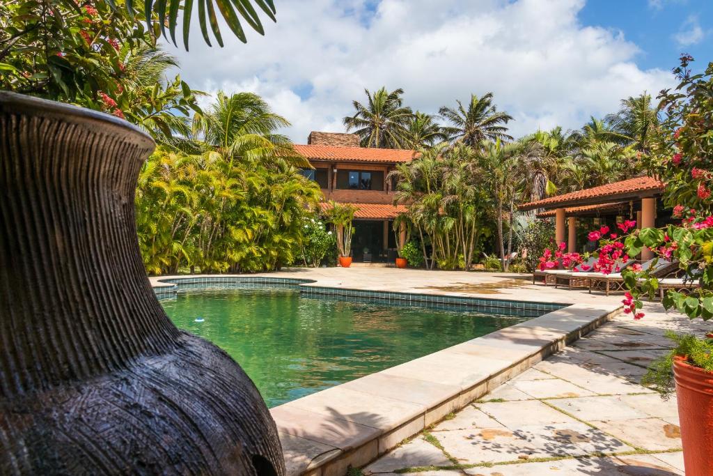 a villa with a swimming pool and a house at Mansao Santa Rita in Cumbuco