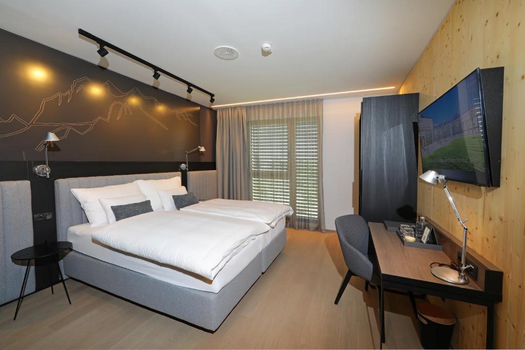 Postel nebo postele na pokoji v ubytování Hotel Steiermarkhof Graz - Aus Holz gebaut, von Hügeln geküsst