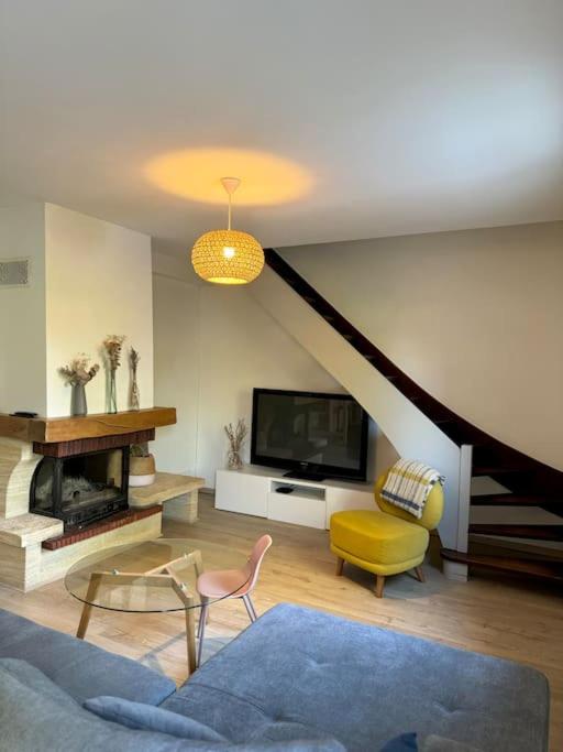 un salon avec un canapé et une télévision dans l'établissement Les Acacias - Maison de campagne, à Saint-Sulpice