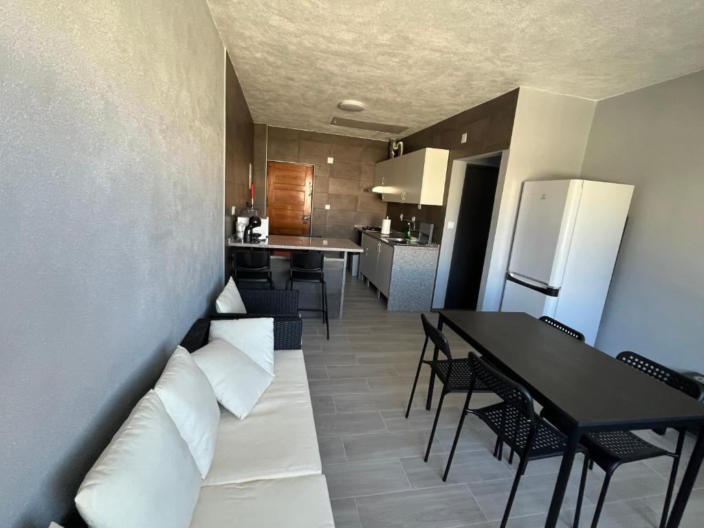 a living room and kitchen with a couch and a table at Sun House - Apartamento in Belas