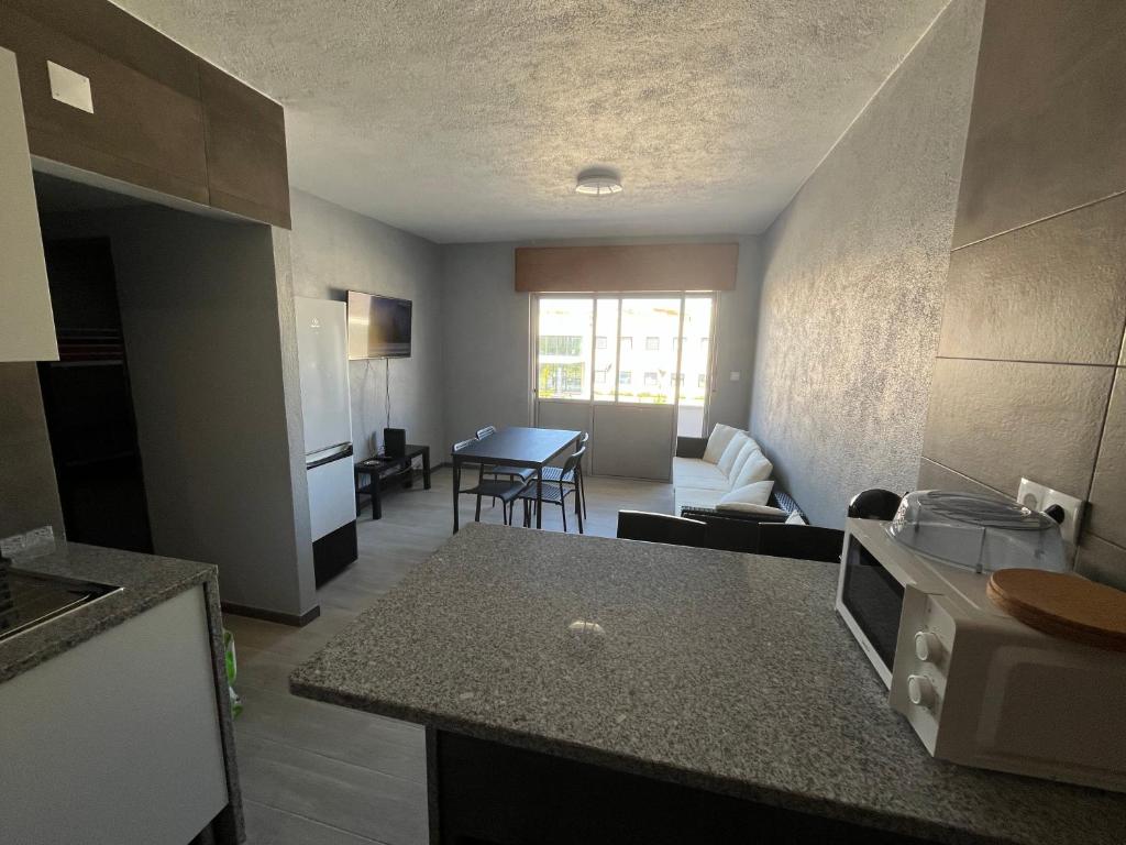 a kitchen and a living room with a table at Sun House - Apartamento in Belas