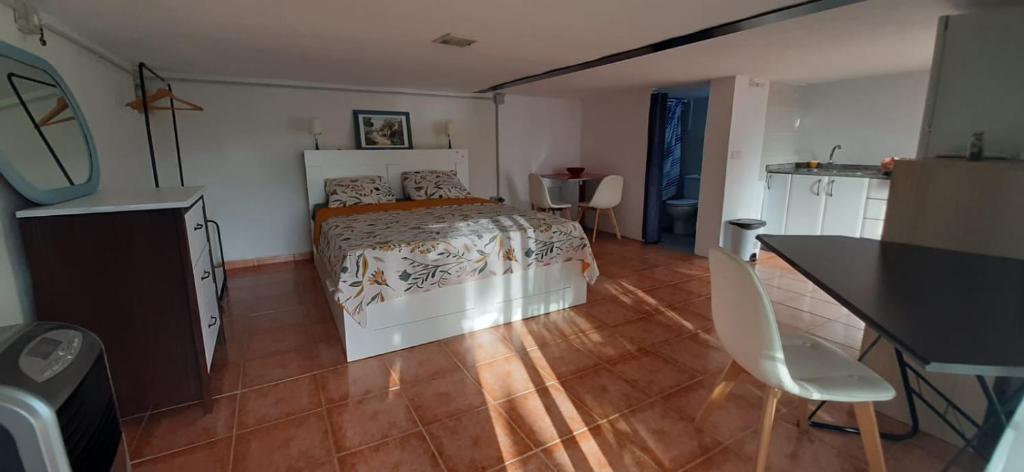 ein Schlafzimmer mit einem Bett und einem Holzboden in der Unterkunft Habitación completa e independiente in Creixell