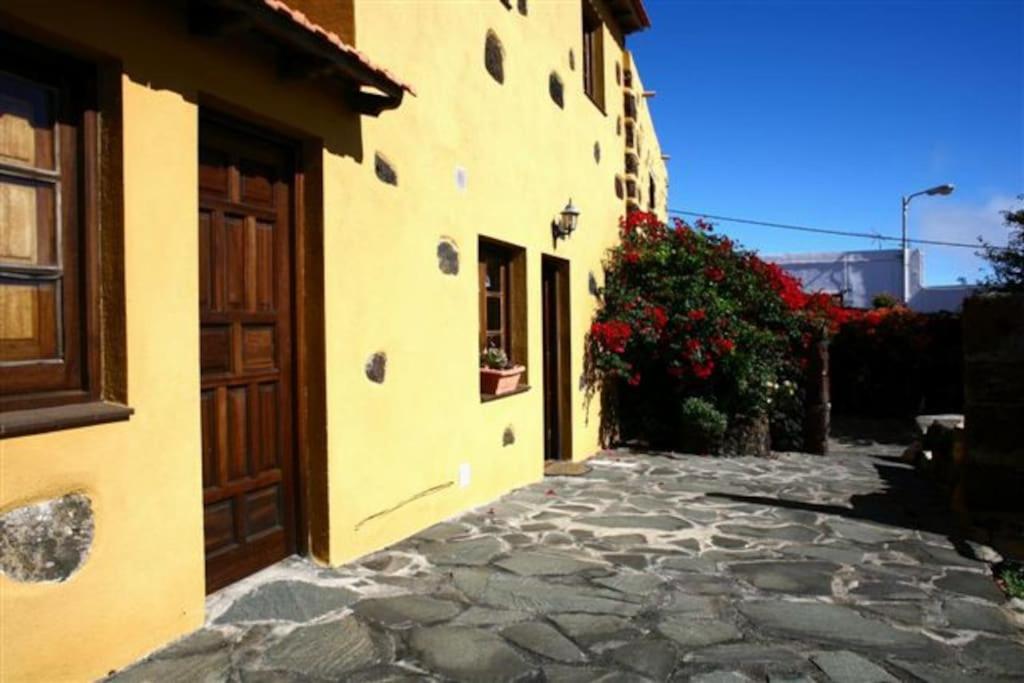 a building with a stone path next to a building with flowers at VV Las Vistas de El Pinar in El Pinar del Hierro