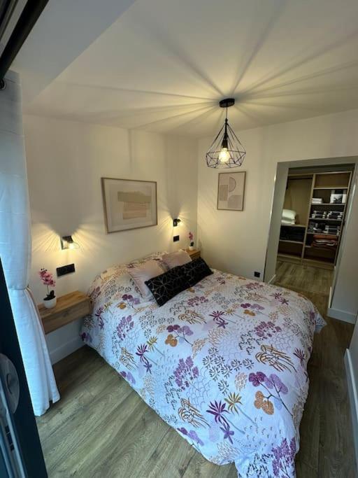 une chambre avec un lit avec un couvre-lit fleuri dans l'établissement Le Briand Appartement 4étoiles Nancy Thermal Cosy avec Terrasse Wifi, à Laxou