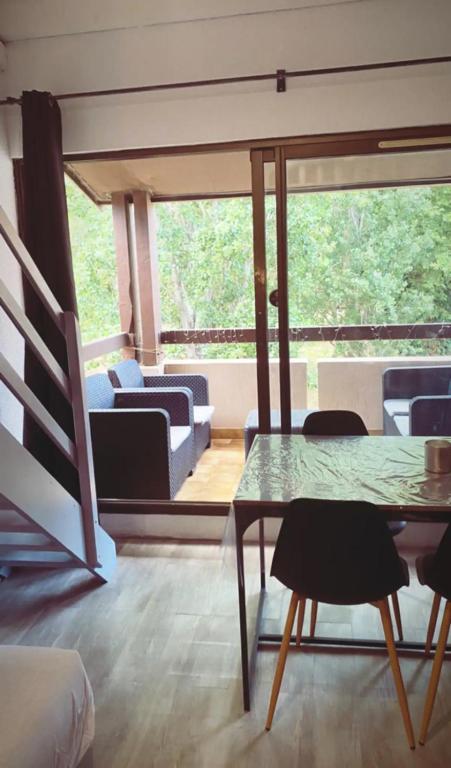 un salon avec une table en verre et des chaises dans l'établissement Appartement avec grande terrasse, à Saint-Cyprien