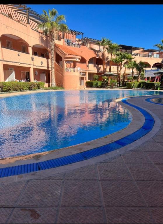 a large swimming pool in front of a building at Beau Duplex à Imi ouaddar in Agadir nʼ Aït Sa