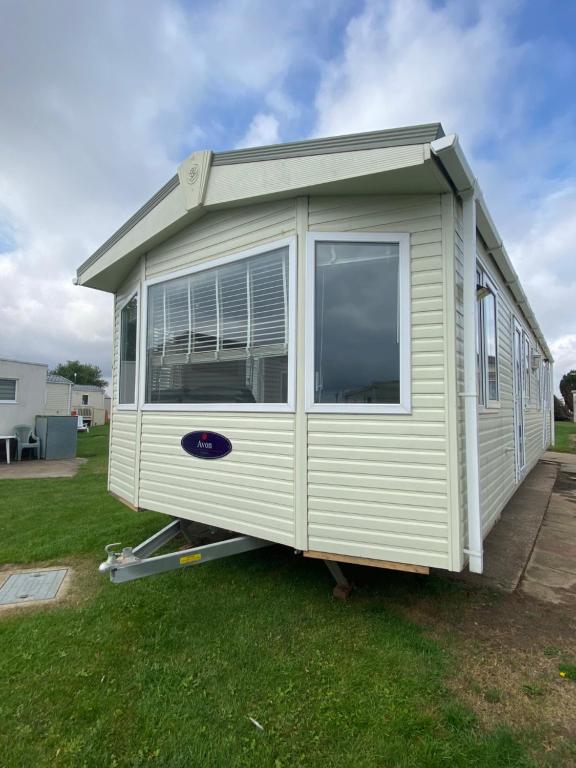 a mobile home is sitting on the grass at Coastal Caravan Holidays - Nightingale 8 in Tunstall