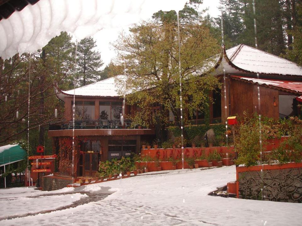una casa con nieve en el suelo delante de ella en Shangrila Hotels and Resort, en Murree
