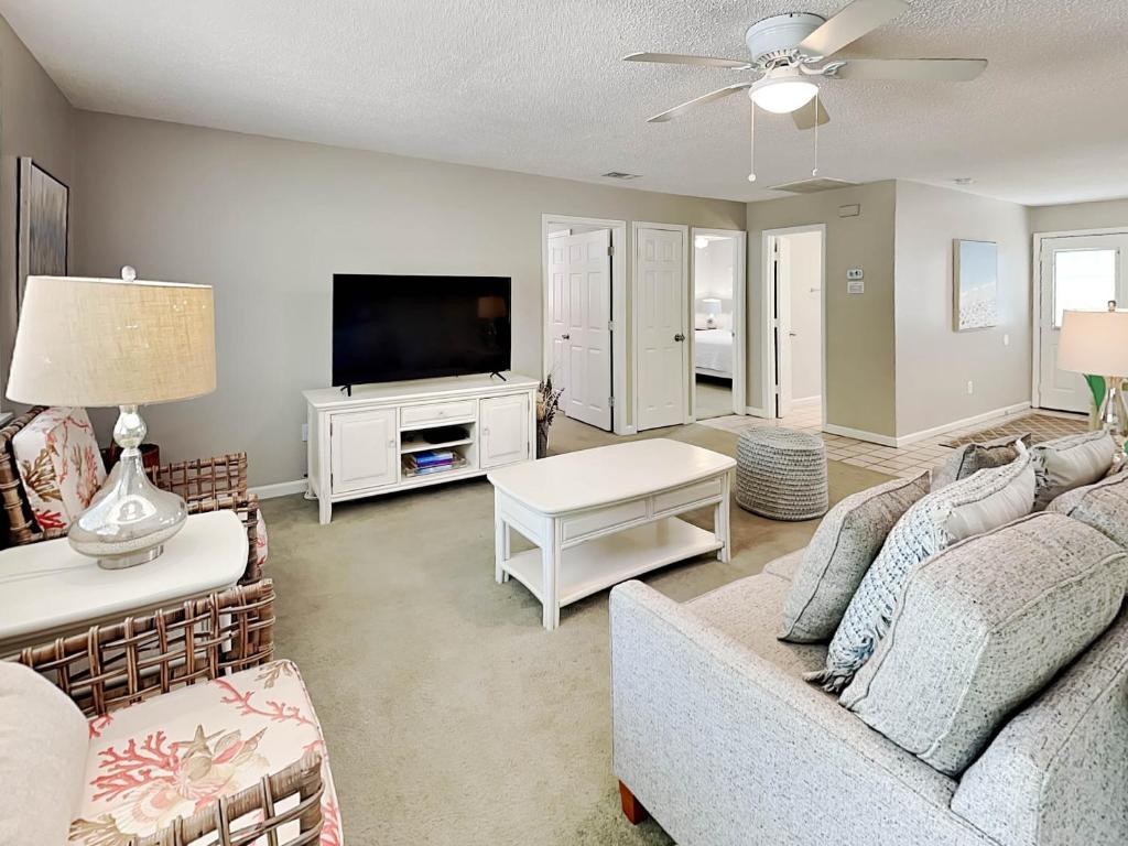 a living room with a couch and a tv at Latitude Adjustment A in Tybee Island