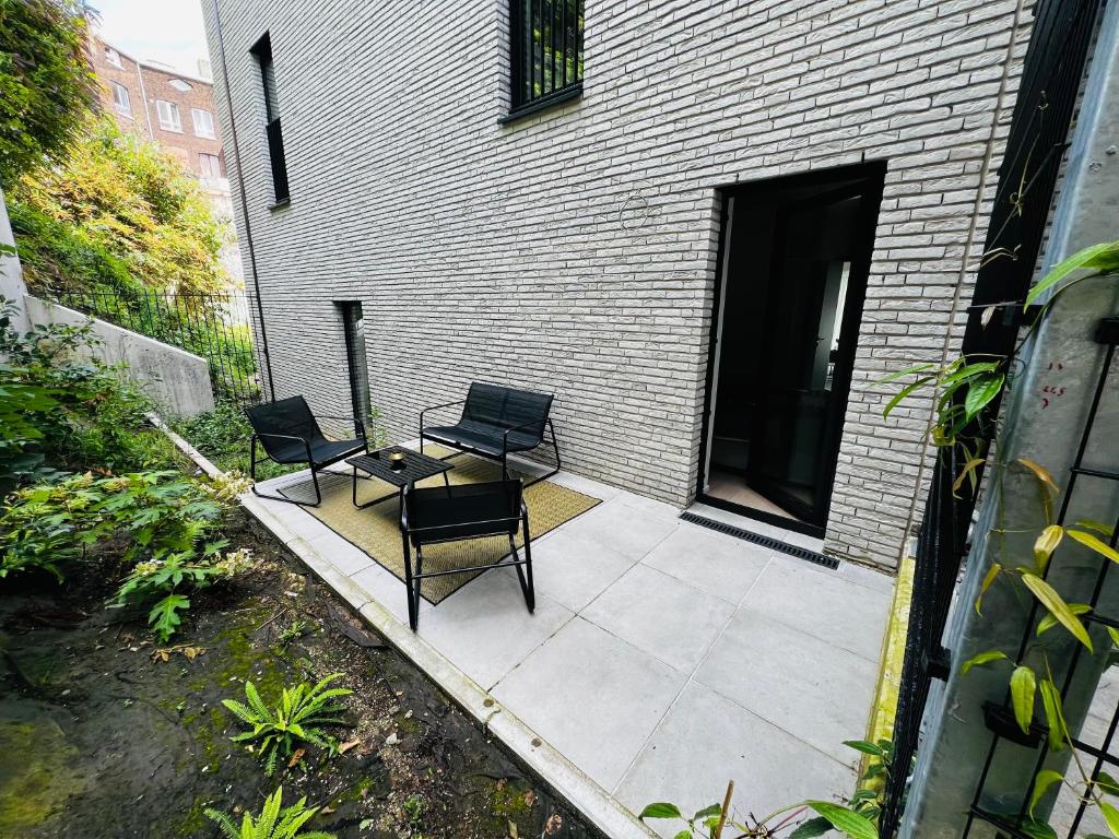 deux chaises et une table sur une terrasse dans l'établissement T & B Trianon - Appartement Chic & Cosy, à Liège