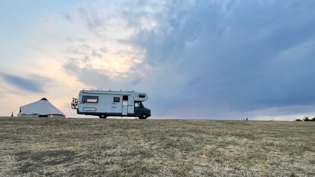 ein Wohnmobil mit einem Zelt auf einem Feld geparkt in der Unterkunft Surfer Mammut in Ipswich