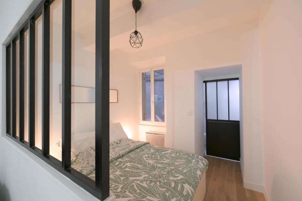 a bedroom with a bed and a window at Appartement T1 bis L'enfilade in Albi