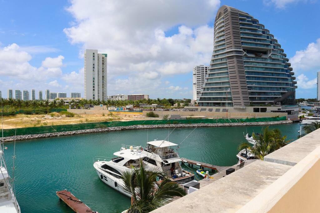 坎昆Luxury Apt with Balcony, Marina Puerto Cancún的建筑物前河里的船