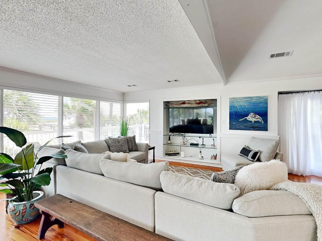 a living room with a white couch and a tv at Oceanside Unit A in Tybee Island