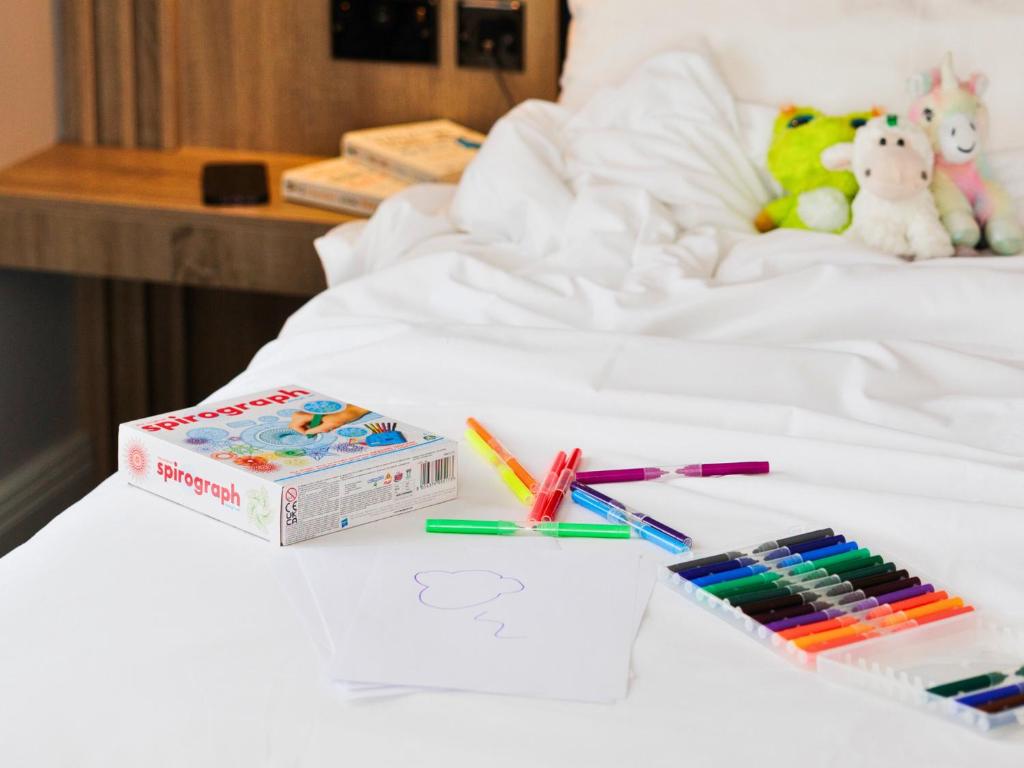 a white bed with a box of crayons and markers at Springfield Hotel in Leixlip