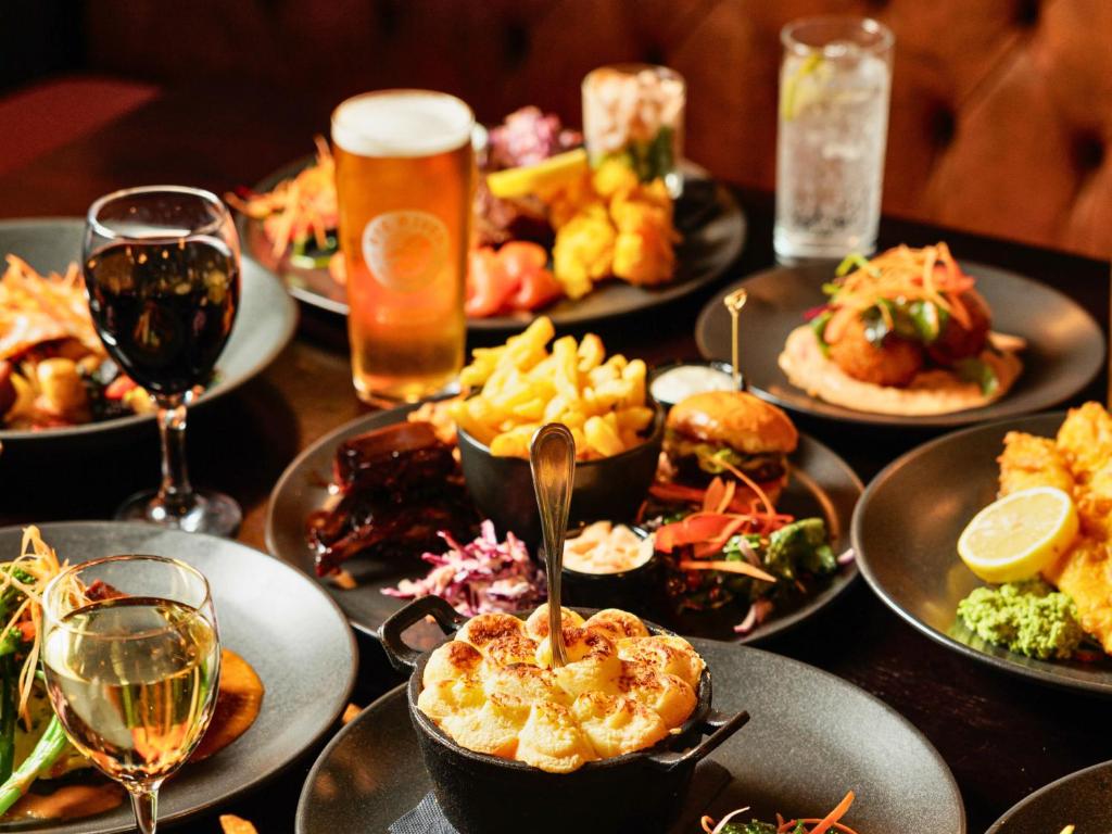 a table with plates of food and glasses of beer at Springfield Hotel in Leixlip