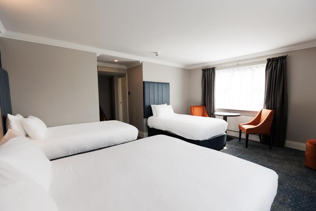 a hotel room with two beds and a desk at Springfield Hotel in Leixlip