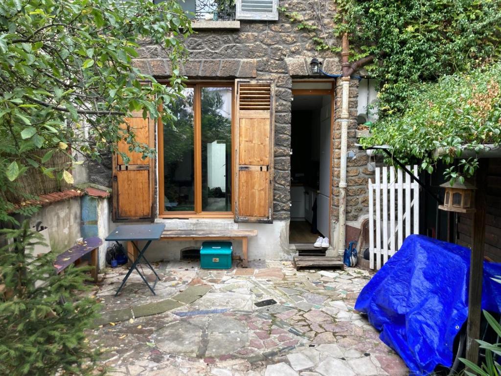 - une entrée pour une maison en pierre avec des portes en bois dans l'établissement Joli appartement avec jardin-Parc de la Villette, à Le Pré-Saint-Gervais