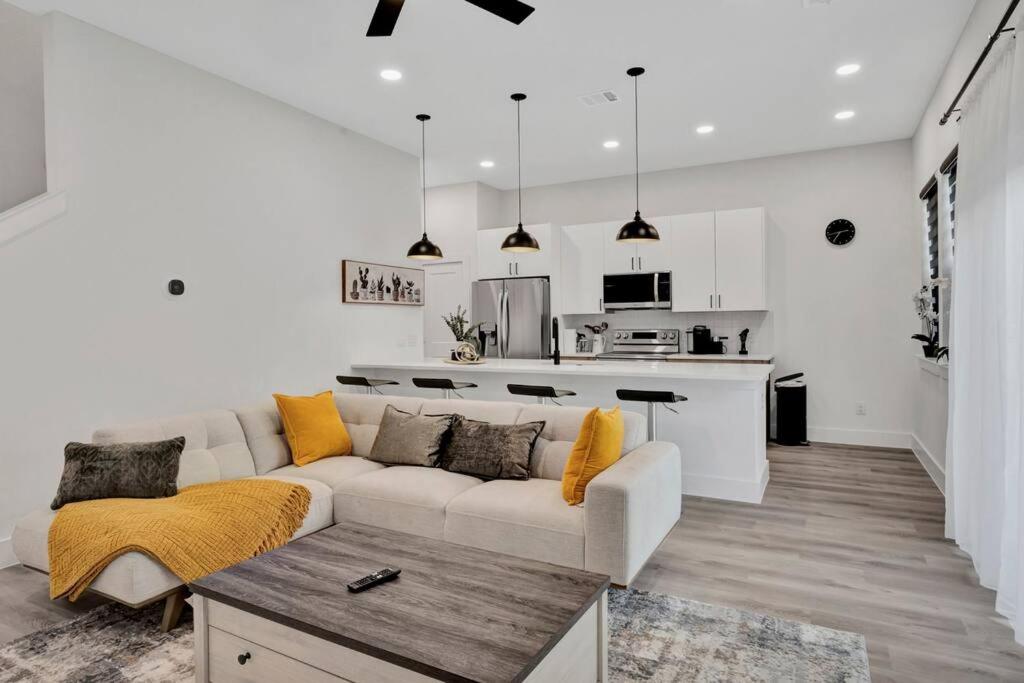 a white living room with a couch and a kitchen at Perfect Dallas Oasis l Pet Friendly l Big Backyard in Oldham