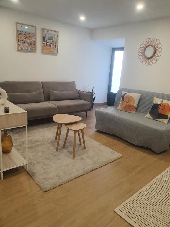 un soggiorno con un divano e un tavolo di Charming Jasmin House a Viseu