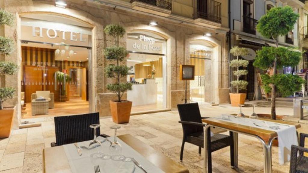 a store with a table and chairs in front of a building at Plaça De La Font in Tarragona