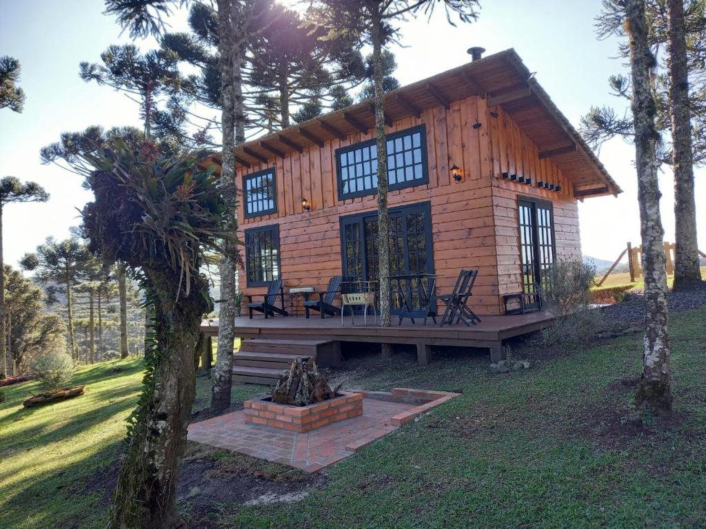 a log cabin with a table and chairs in front of it at Cabana Van Gogh in Campo Alegre