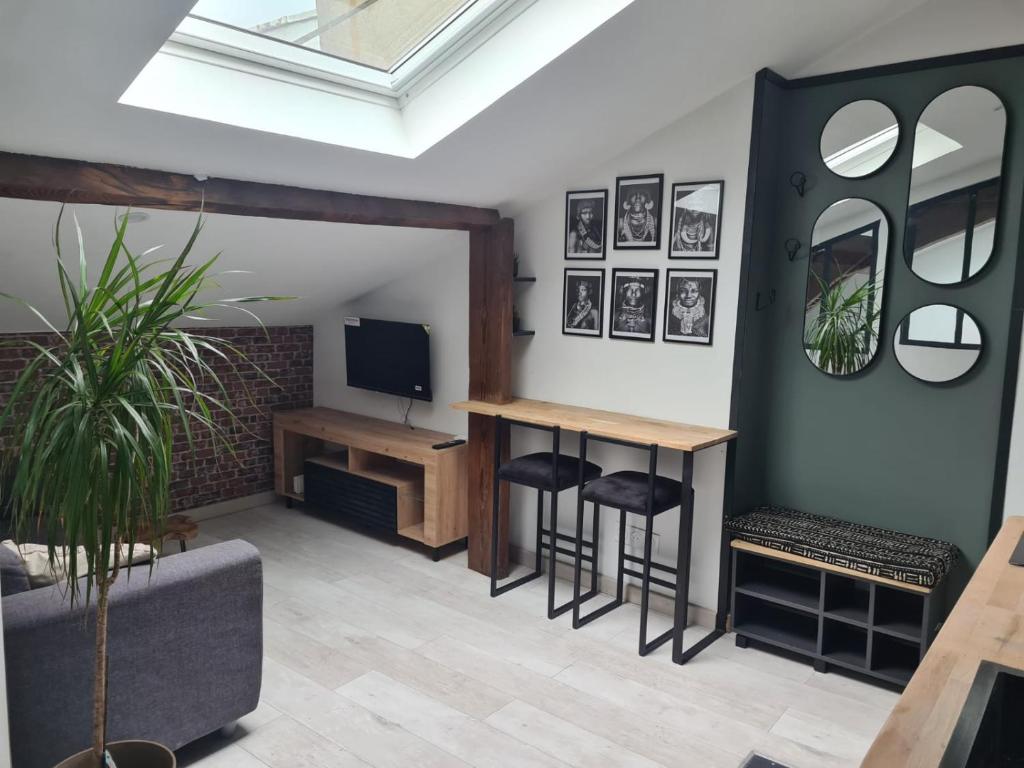 un salon avec une télévision, une table et des tabourets dans l'établissement Charmant mini loft atypique proche paris 13, à Ivry-sur-Seine