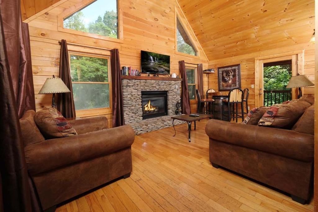 a living room with two couches and a fireplace at Thunder Bear Hideaway Roar Into Relaxation in Pigeon Forge
