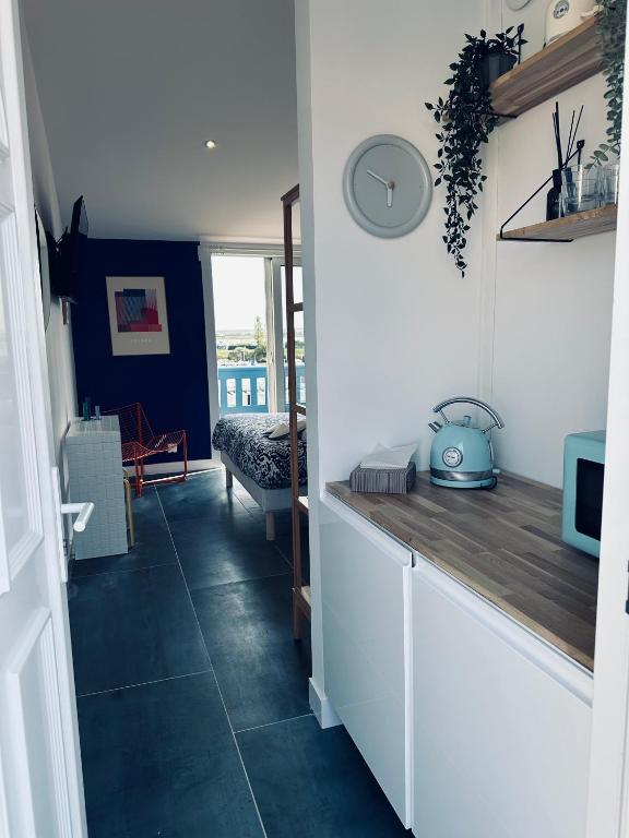 - une cuisine avec des placards blancs et un sol bleu dans l'établissement Le logis de l estuaire, à Meschers-sur-Gironde