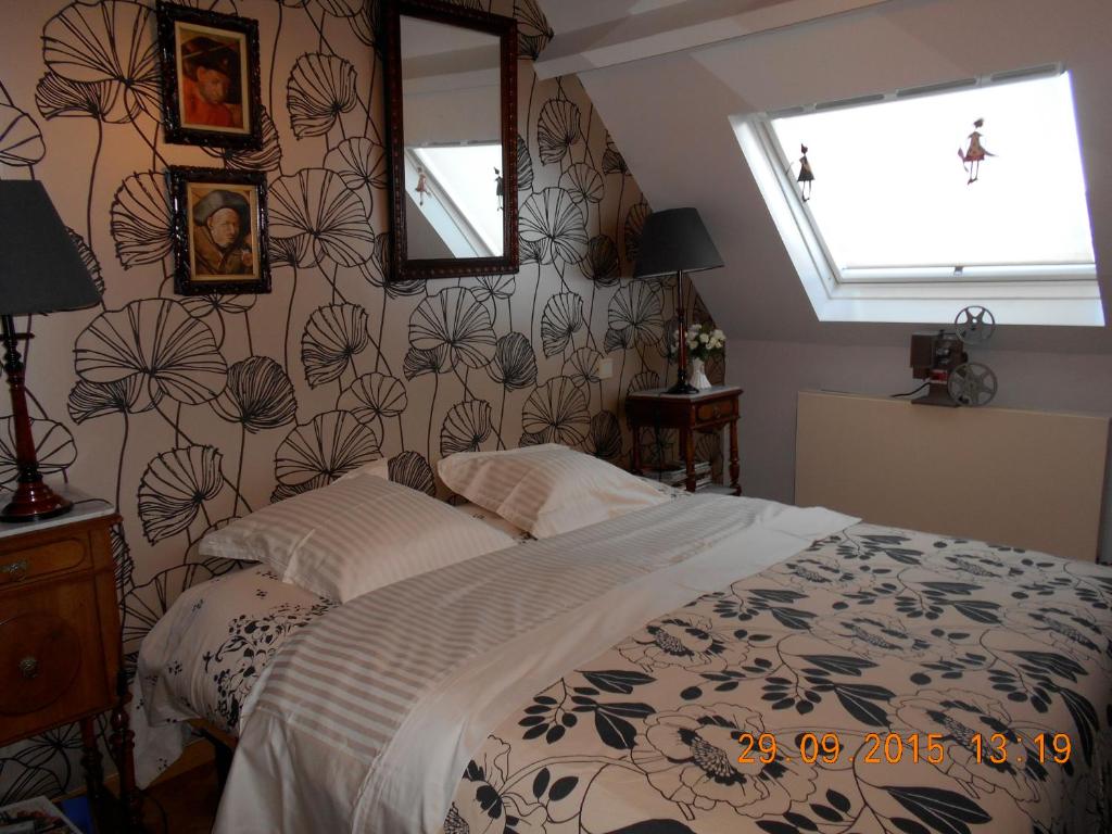 a bedroom with a bed with a flowery wallpaper at B&B De Mansarde in Diest