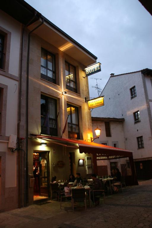 a restaurant with people sitting at tables in front of a building at Hotel Los Molinos in Llanes