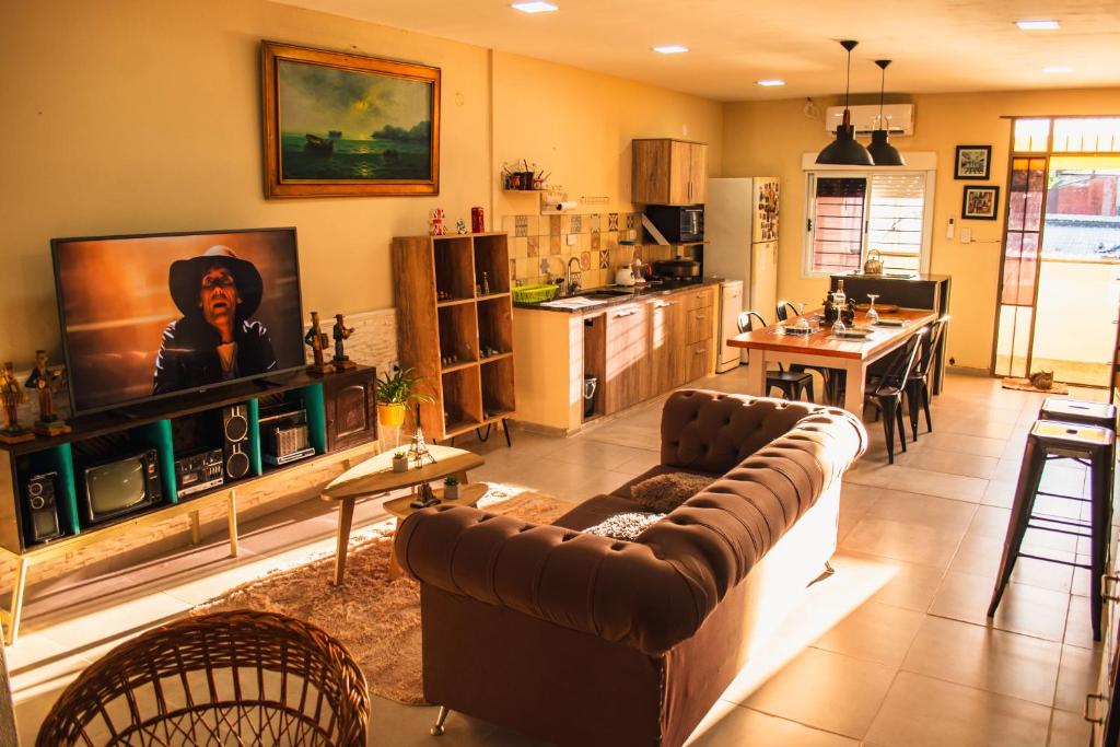 Una sala de estar con un sofá y una cocina. en Dpto a 4 min del Shopping y Centro de Convenciones, en Corrientes
