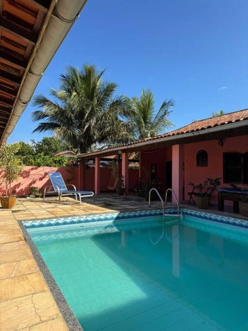 a swimming pool in front of a house at Recanto do Sol em Praia Seca in Araruama