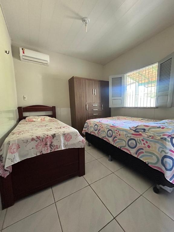 ein Schlafzimmer mit zwei Betten und einem Fenster in der Unterkunft Casa de Temporadas Alto Bonito in Luis Correia