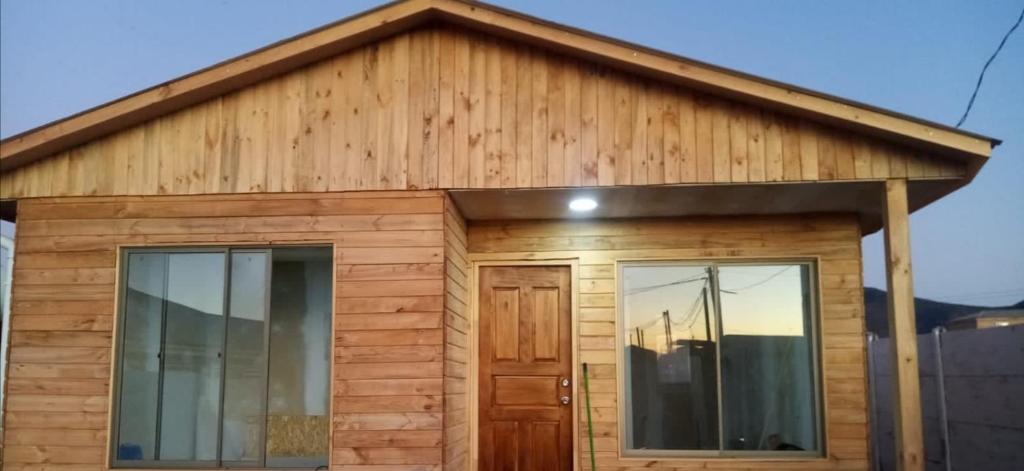 a wooden house with two windows and a door at Herradura Sur Oriente in Coquimbo