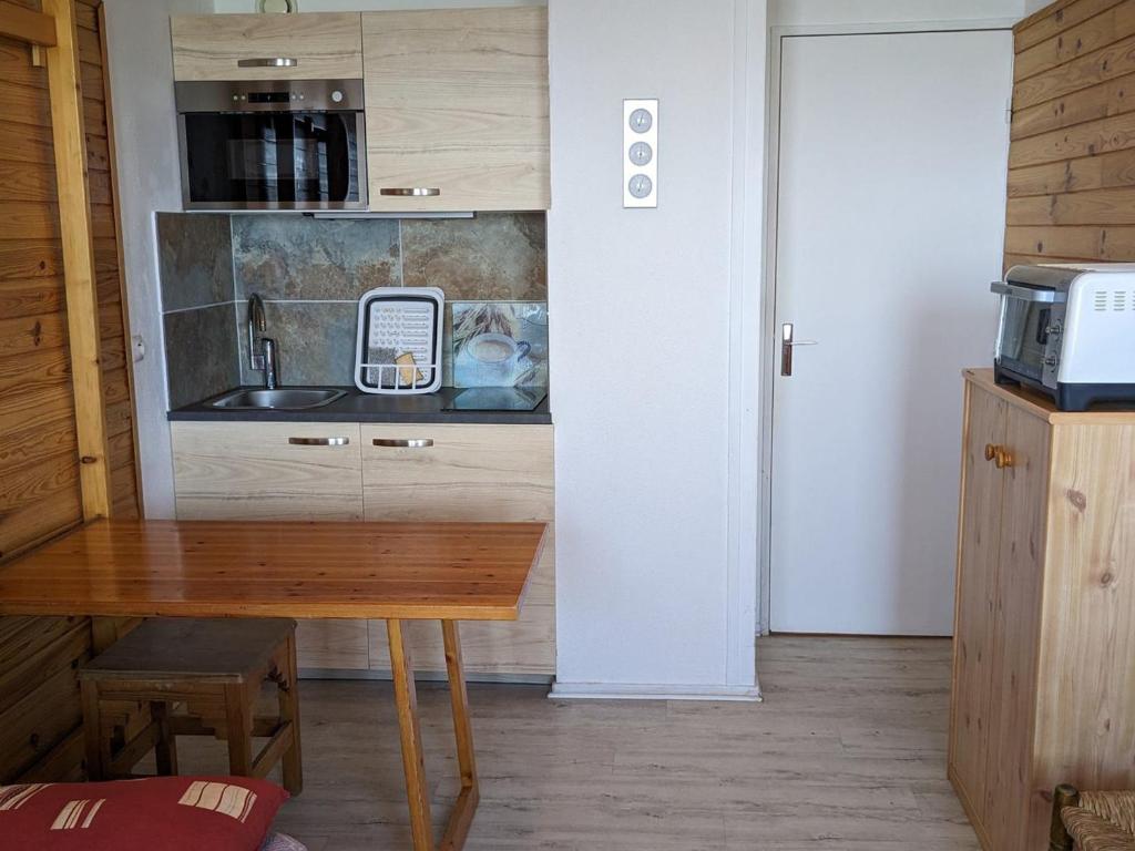 - une cuisine avec une table en bois et un évier dans l'établissement Studio cosy pour 3 pers avec balcon et équipements de confort aux Adrets-Prapoutel - FR-1-557-130, à Les Adrets