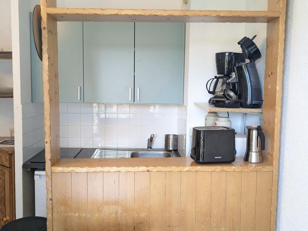 une cuisine avec un évier et un micro-ondes dans l'établissement Studio cabine 4 pers, pied des pistes, balcon, exposé sud - FR-1-557-132, à Les Adrets