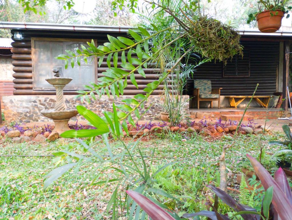 a garden with a bench in front of a house at Casa de campo el lapacho in Colonia Mbopicuá
