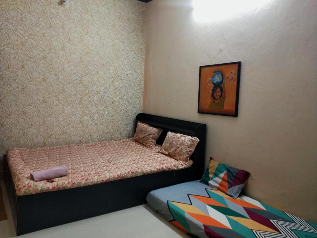 a small bedroom with a bed and a couch at Advait Home Stay in Ujjain