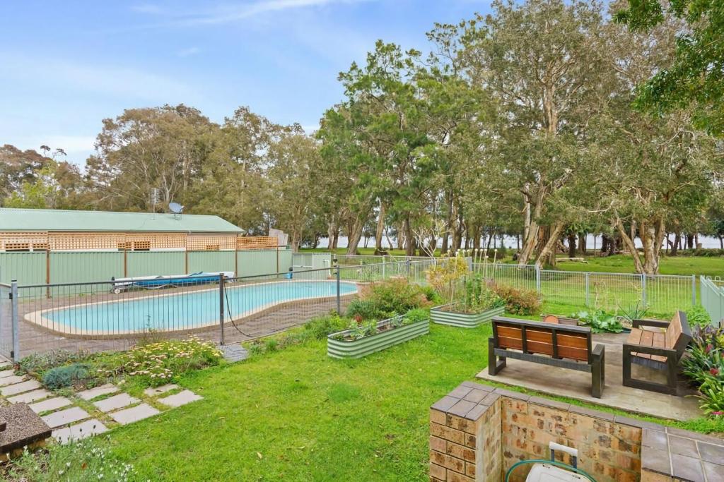 a park with a swimming pool and a bench at Waterfront Pet Friendly Abode Toukley NSW in Toukley