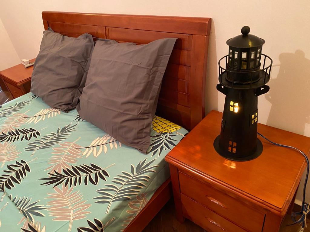 a bed with two pillows and a lamp on a night stand at Appartement T4 Standing Diégo-Suarez in Antsiranana