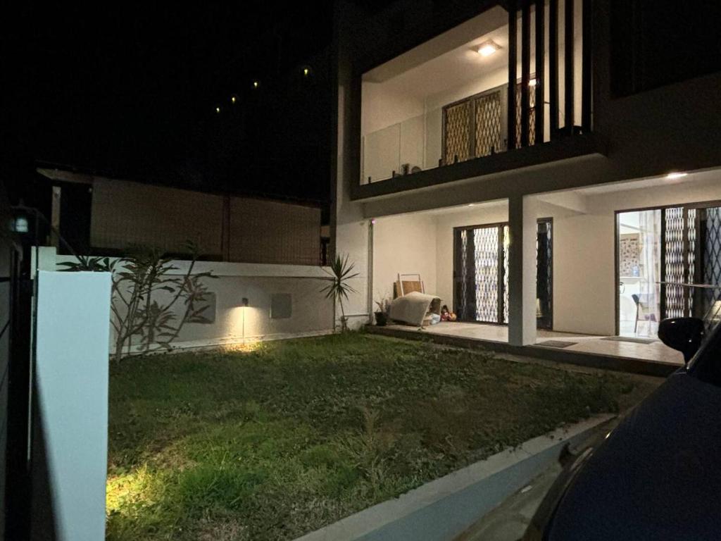 a large house with a yard in the nighttime at Évasion Tropicale à 5 min des Plages in Albion