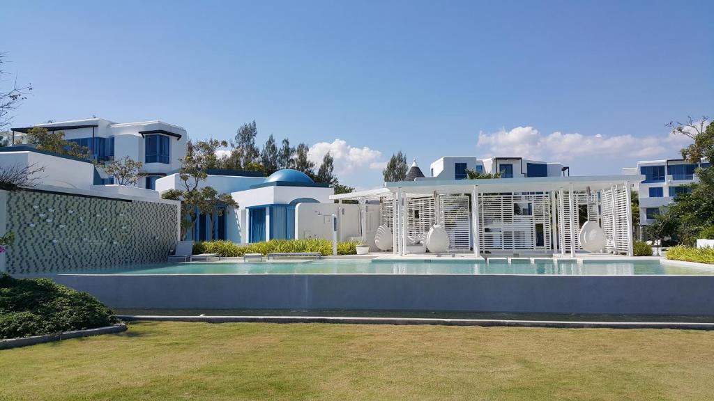 una casa grande con piscina frente a ella en The Crest Santora Huahin 4 Fl H(Monthly rate), en Hua Hin