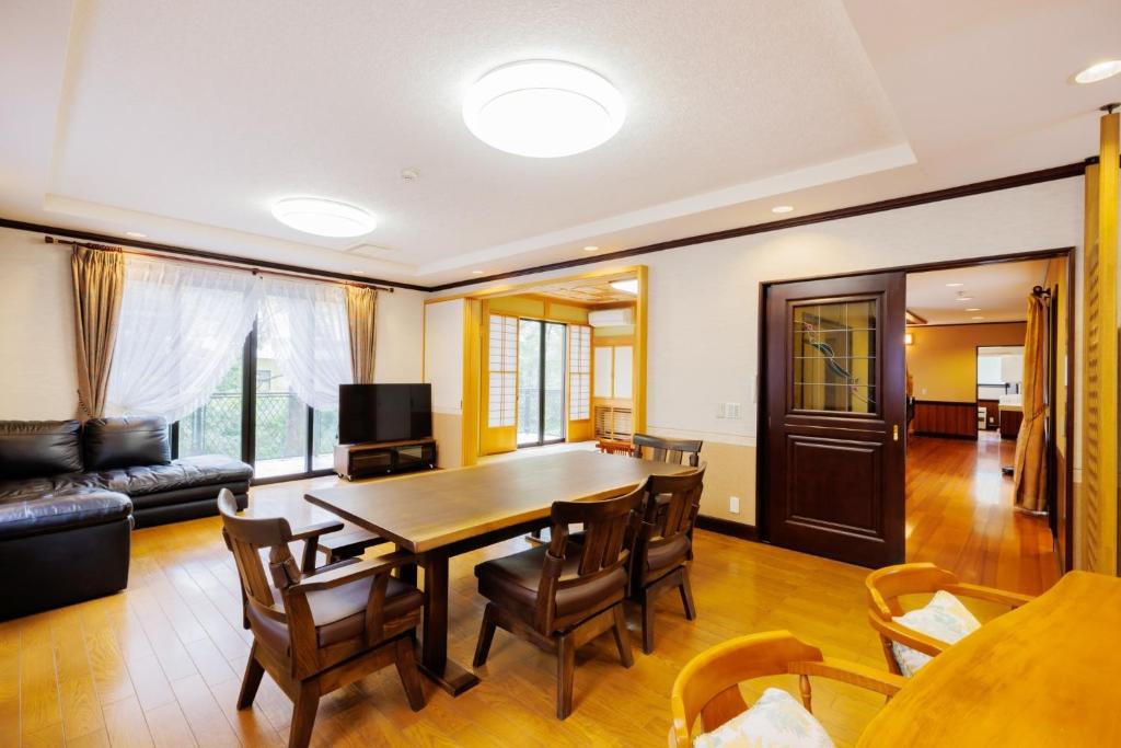 ein Wohnzimmer mit einem Holztisch und Stühlen in der Unterkunft HIBIKI - Zao Sansuien Gaia Resort - Vacation STAY 54084v in To-katta
