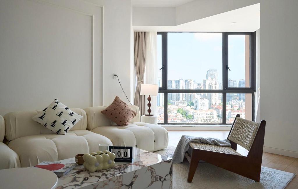 a living room with a white couch and a window at Eastern Hub - Bund Branch Near Yuyuan Garden Convenient Subway in Shanghai