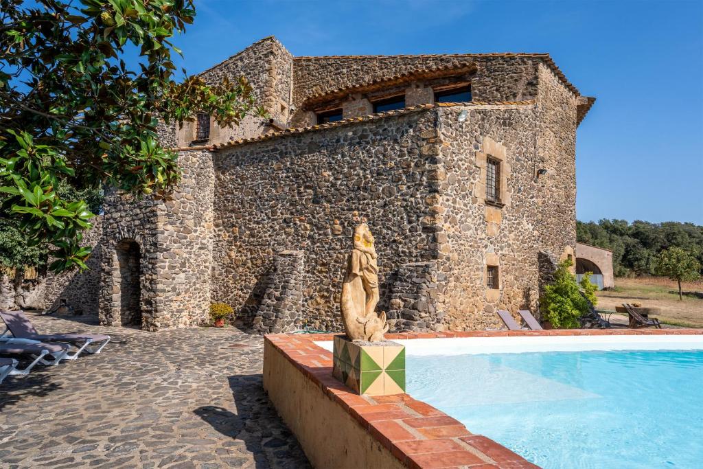 a stone building with a swimming pool in front of it at Mas Català in Rupiá