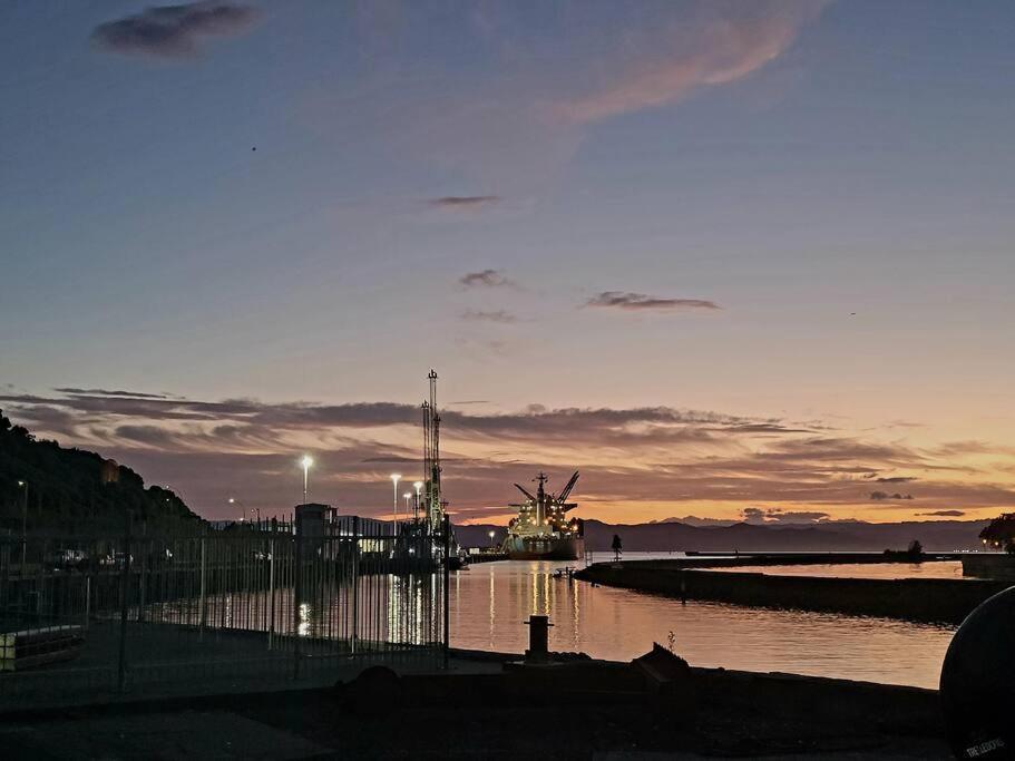 a boat in a body of water at sunset at Esplanade Townhouse in Gisborne