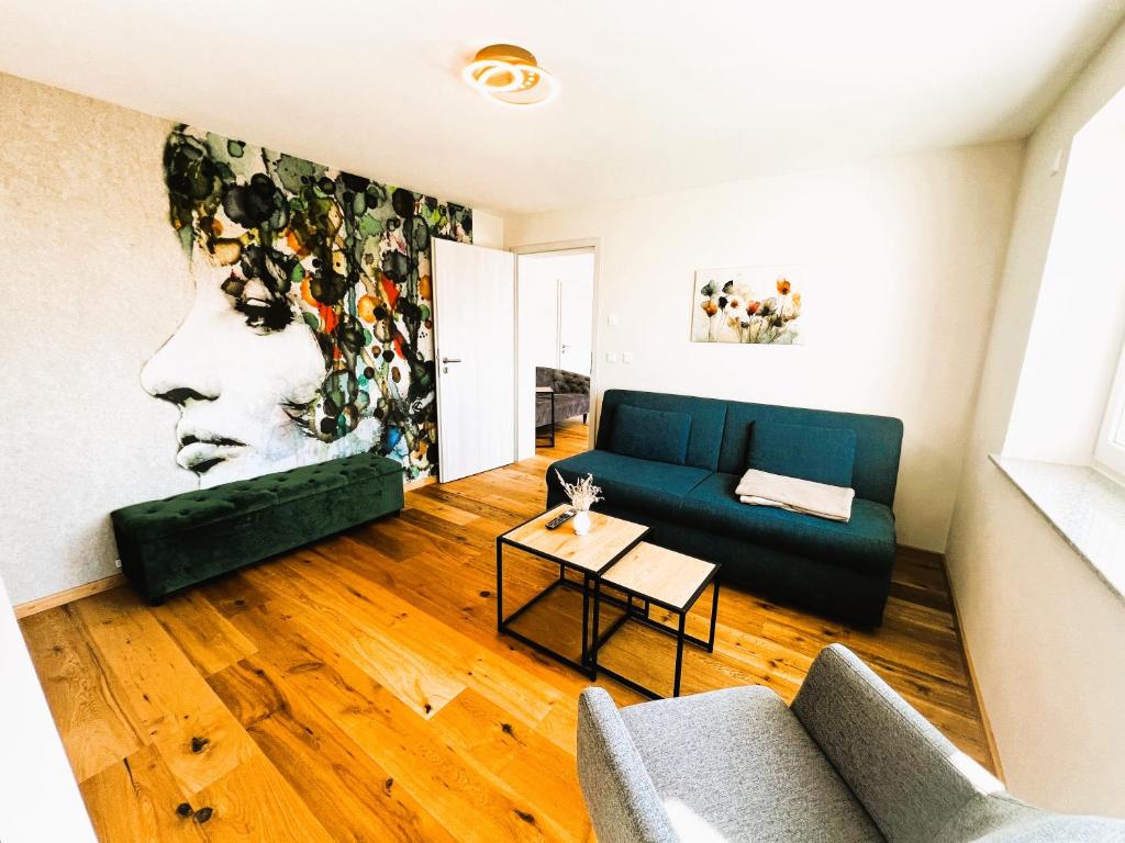 a living room with a blue couch and a painting at Ferienhaus DONAUzeit in Sigmaringen