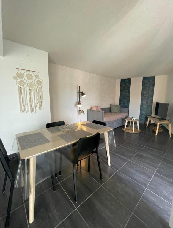 un salon avec une table, des chaises et un canapé dans l'établissement Yoyo's appart, à Perpignan