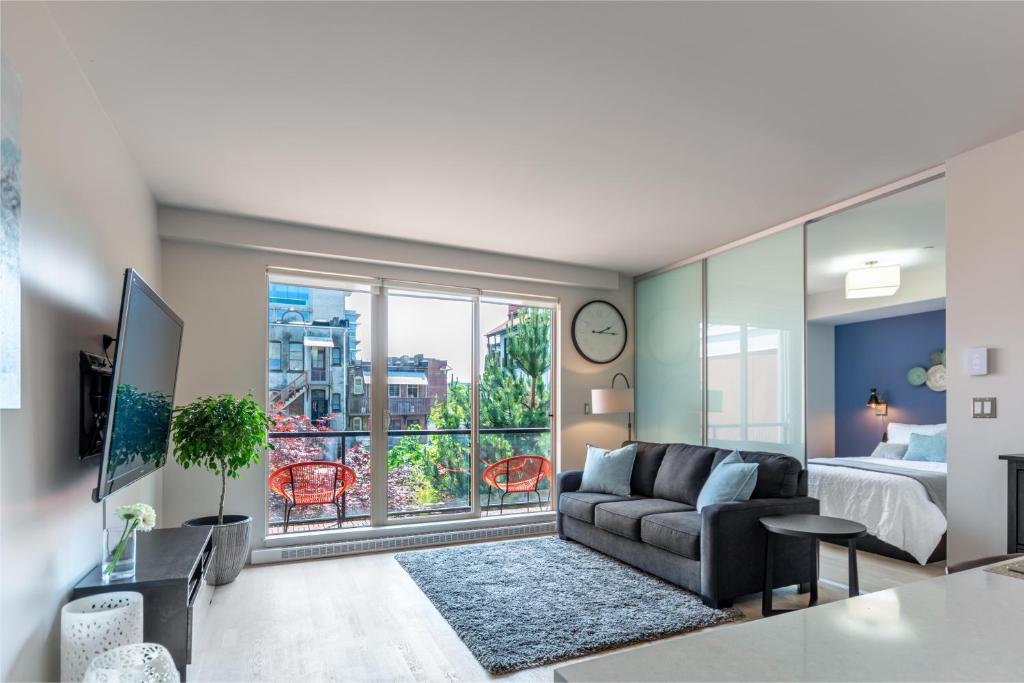 a living room with a couch and a bed and a window at Sun-Drenched Sophistication in Victoria